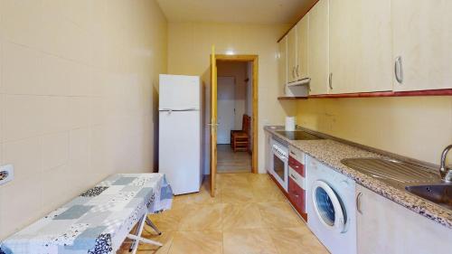 a kitchen with a white refrigerator and a sink at Chalet BS in Albalate de Zorita