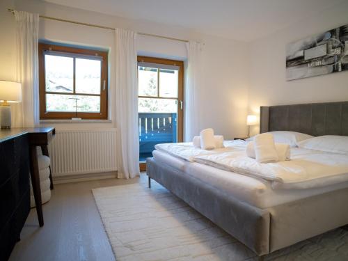 a bedroom with a bed and a desk and two windows at Apartment Bachweg in Forstau