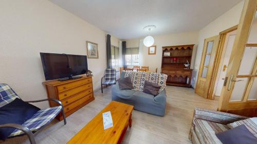 a living room with a couch and a tv at Chalet BS in Albalate de Zorita