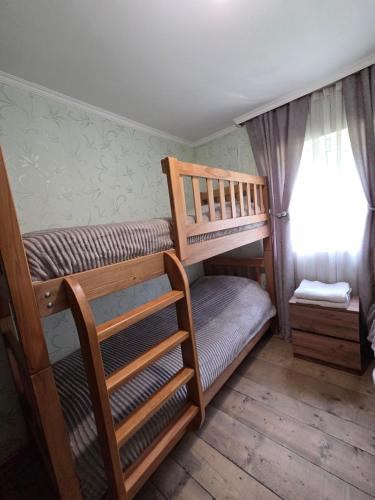 two bunk beds in a room with a window at Chvibiani Guesthouse & Bar in Ushguli