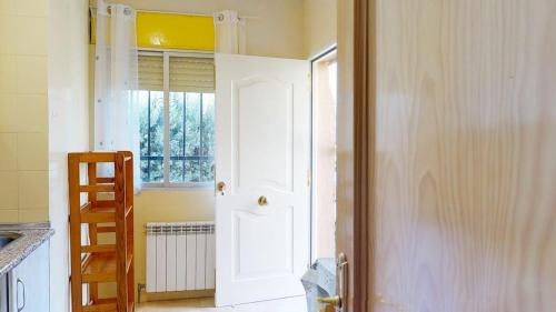 a kitchen with a white door and a window at Chalet BS in Albalate de Zorita