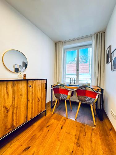 a dining room with a table and chairs and a mirror at Spacious 5BR shared Apartment Near Kaufpark Alterlaa in Vienna