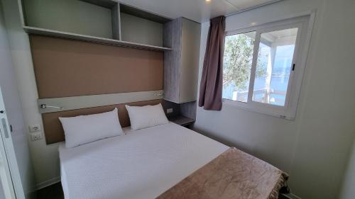 a small bedroom with a bed and a window at Camping La Rocca in Manerba del Garda