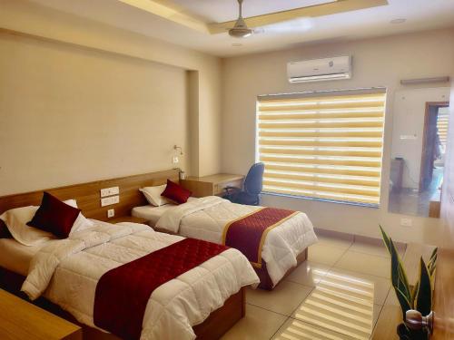 a hotel room with two beds and a window at Ikigai Business Rooms by Zoliva Homes in Cochin