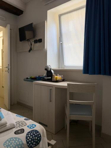 a kitchen with a table and a chair and a window at BelSorrisoVarese - Elegance City Residence Private Parking -Reservation Required- in Varese