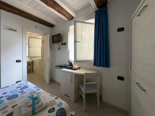 a bedroom with a bed and a table and a bathroom at BelSorrisoVarese - Elegance City Residence Private Parking -Reservation Required- in Varese