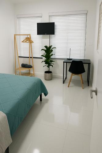 a bedroom with a bed and a desk and a plant at Santamaria Fort Lauderdale Airport in Fort Lauderdale