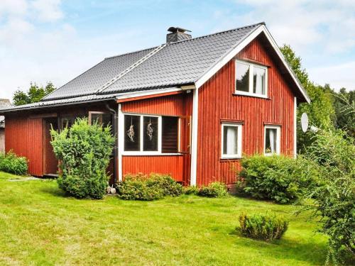 a red house with a black roof at 6 person holiday home in BENGTSFORS-By Traum in Näs