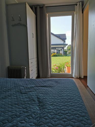 ein Schlafzimmer mit einem Bett und einem großen Fenster in der Unterkunft EcoRelax in Błotnik