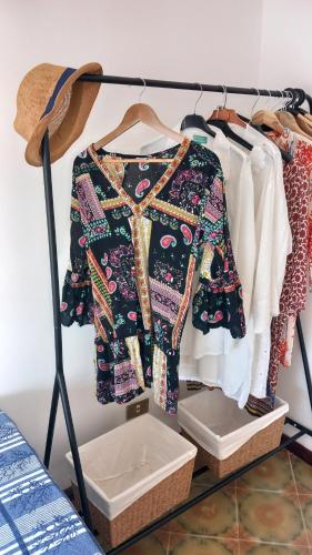 ein Ständer mit einem Kleid und anderen Kleidungsstücken in der Unterkunft Domus Maregi in Marina di Ragusa