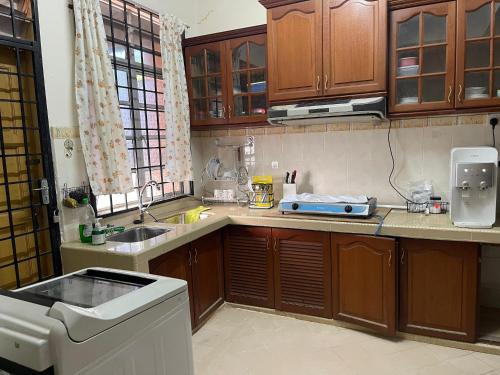 a kitchen with wooden cabinets and a sink at Homestay Hanan in Kuala Terengganu