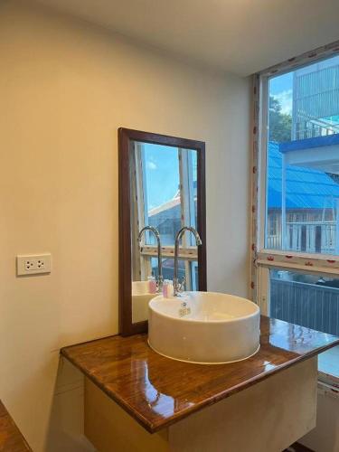 a bathroom with a sink and a mirror on a counter at Eastan Golf View ChiangMai in Chiang Mai