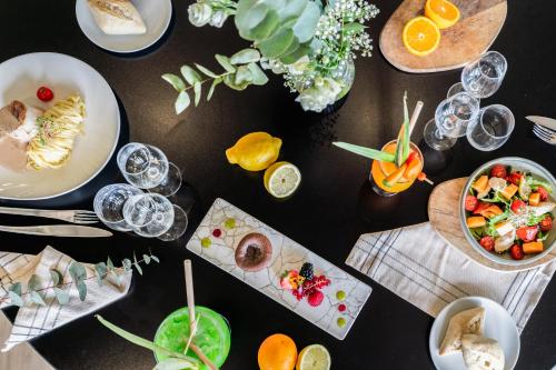 a table with plates of food and glasses of wine at Mercure Orléans Portes de Sologne in Ardon