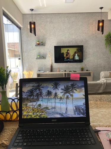 a laptop computer sitting on a table in a living room at Boa Vista · Amplo Ap. a 5 km do Hospital Regional Hans Dieter in Joinville