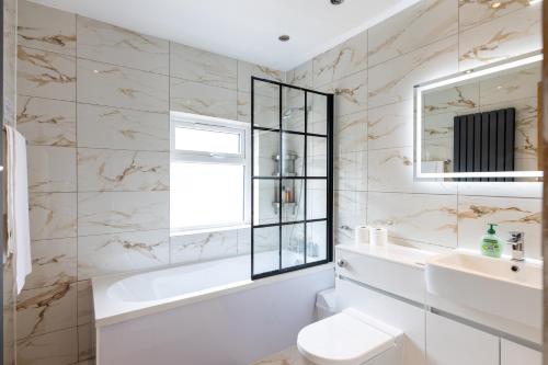 a bathroom with a sink and a toilet and a mirror at Perfect Booking Stylish 2 Bed Home In Stockport in Manchester