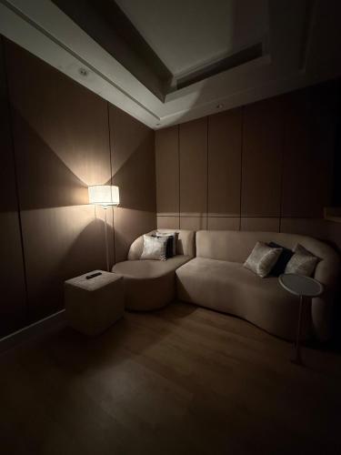 a living room with a white couch and a lamp at Luxury Modern Apartment with smart entry in Jeddah