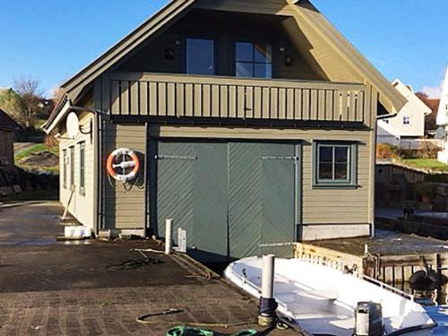 una casa con un garage con una barca nel vialetto di 7 person holiday home in bru-By Traum a Bru