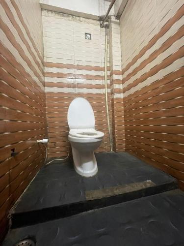 a bathroom with a toilet in a wooden wall at T Heritage Hotel in Chheonki