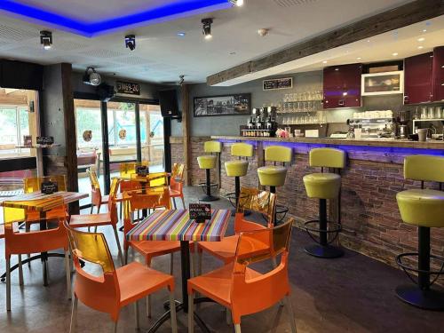 a restaurant with orange chairs and tables and a bar at Auberge de Jeunesse HI Le Mont-Dore in Le Mont-Dore