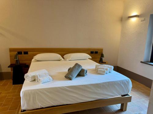 a large white bed with two pillows on it at The Monteleone Umbria Retreat in Monteleone dʼOrvieto