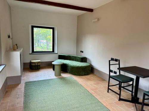 a living room with a green couch and a table at The Monteleone Umbria Retreat in Monteleone dʼOrvieto