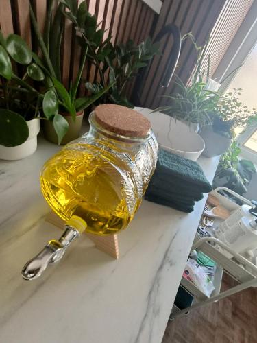 a bottle of honey on a table with plants at 2Bangkok residence in Ghent