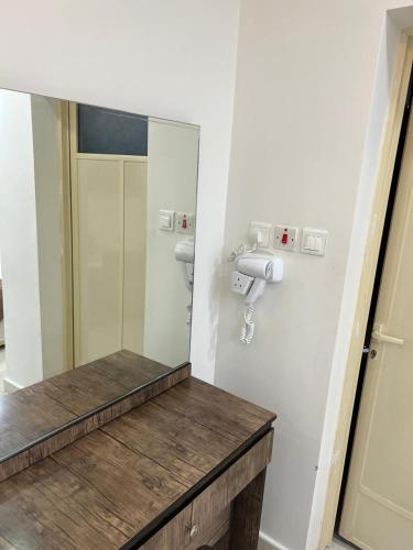 a bathroom with a mirror and a sink at Adeem Serviced Apartments in Buqayq
