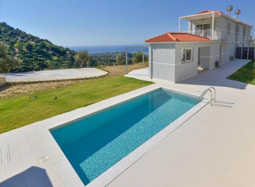 a villa with a swimming pool and a house at Gold Sun Villa in Ratzaklíon