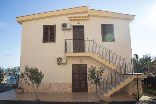 a small white house with a staircase on it at B&B La Veranda in Licata