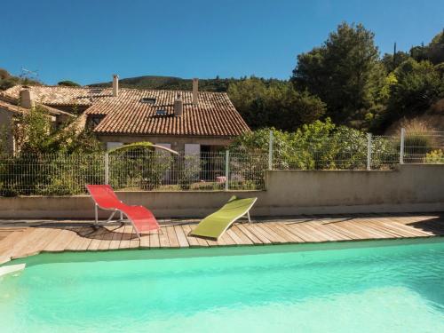 two chairs sitting on a deck next to a swimming pool at Sunny Escape to Serenity in Fraissé-des-Corbières
