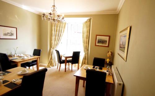 a dining room with a table and chairs and a window at The Lychgate in Caldicot