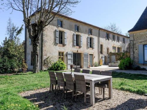 a table and chairs in front of a building at Retreat Near Siorac-en-Périgord in Saint-Germain-de-Belvès