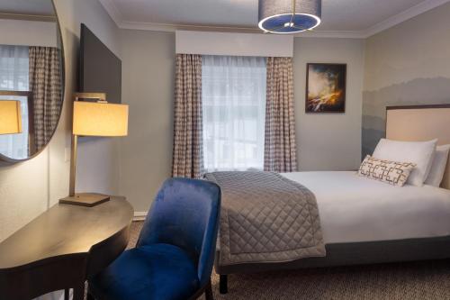 a hotel room with a bed and a desk and a chair at Mercure Blackburn Dunkenhalgh Hotel & Spa in Blackburn