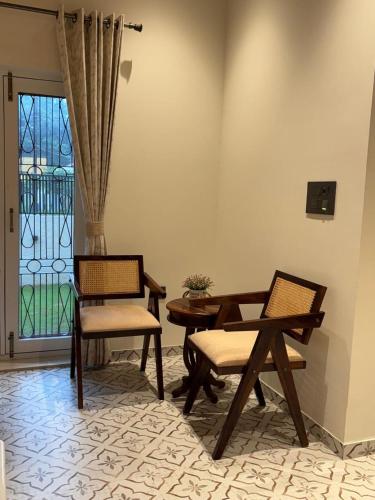 a living room with two chairs and a table at Prantara in Dehradun