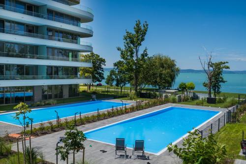 an image of a swimming pool in front of a building at MyFlat Wave Beach39 Apartment in Siófok