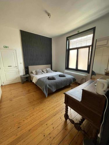 a bedroom with a bed and a table in it at Maison du Rempart in Bruges