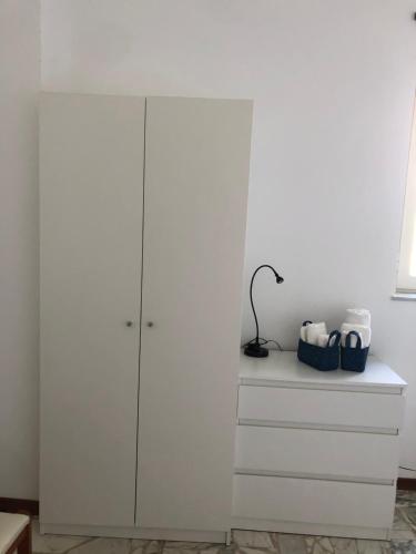 a white cabinet with a lamp on top of it at Casa La Lavanda in Nicosia