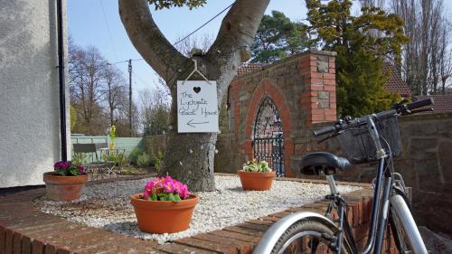 a bike parked next to a tree with a sign on it at The Lychgate in Caldicot