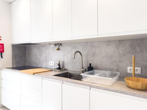a kitchen with white cabinets and a sink at Diana's House - Nazaré in Nazaré