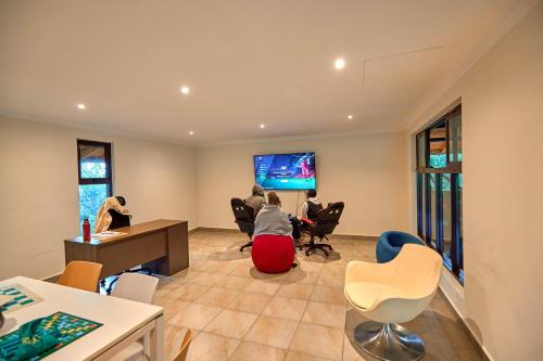 a group of people sitting in a room with a flat screen tv at Charity Chalet in Naivasha