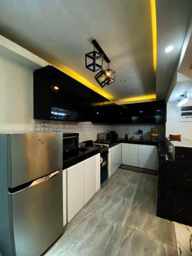 a kitchen with stainless steel appliances and black cabinets at Phoenix Bliss - Amber in General Trias