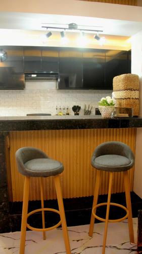 a kitchen with two stools sitting at a counter at Phoenix Bliss - Amber in General Trias