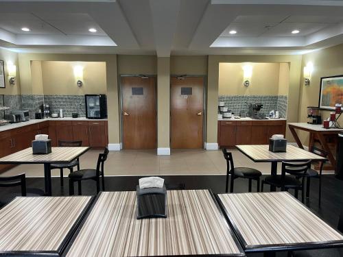 a restaurant with wooden tables and chairs and a kitchen at Days-Inn by Wyndham Cedartown in Cedartown