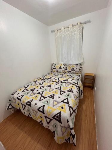 a bedroom with a bed with a black and white comforter at 2-Storey Town House 2 Bedroom in Conel