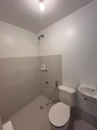 a white bathroom with a toilet and a sink at 2-Storey Town House 2 Bedroom in Conel