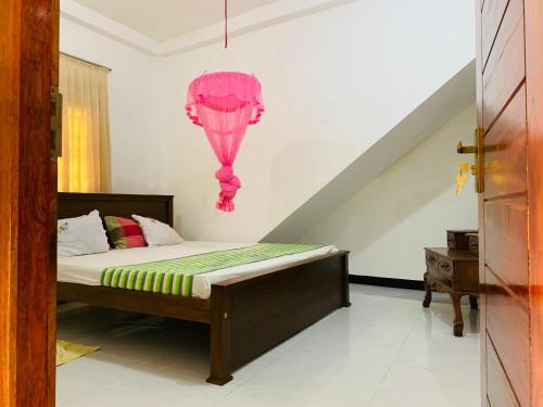 een slaapkamer met een bed met een roze octopus aan de muur bij New Mango Villa in Matara