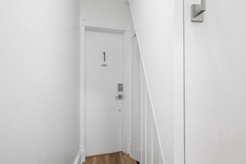 a hallway with white walls and a door at Pittsburgh Millvale Modern and Cozy 1 Bedroom Apartment with Parking in Millvale