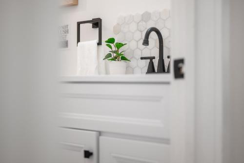 a white bathroom with a sink and a faucet at Pittsburgh Millvale Modern and Cozy 1 Bedroom Apartment with Parking in Millvale