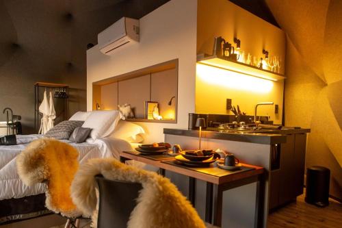 a bedroom with a bed and a kitchen with a sink at Domo nas Alturas! Lareira, Hidro e Céu Estrelado in Rancho Queimado
