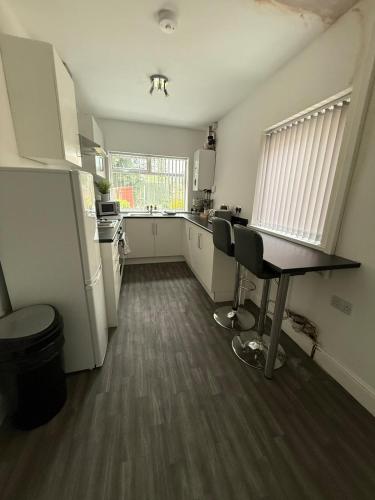 a kitchen with a table and chairs in a room at Stylish 4 Bed for long and short term stays in Longbridge